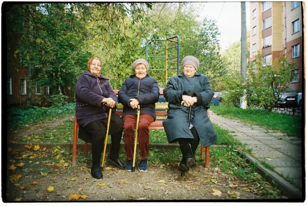 pexels-photo-10158932-10158932 Three senior women with walking sticks sitting on a park bench.