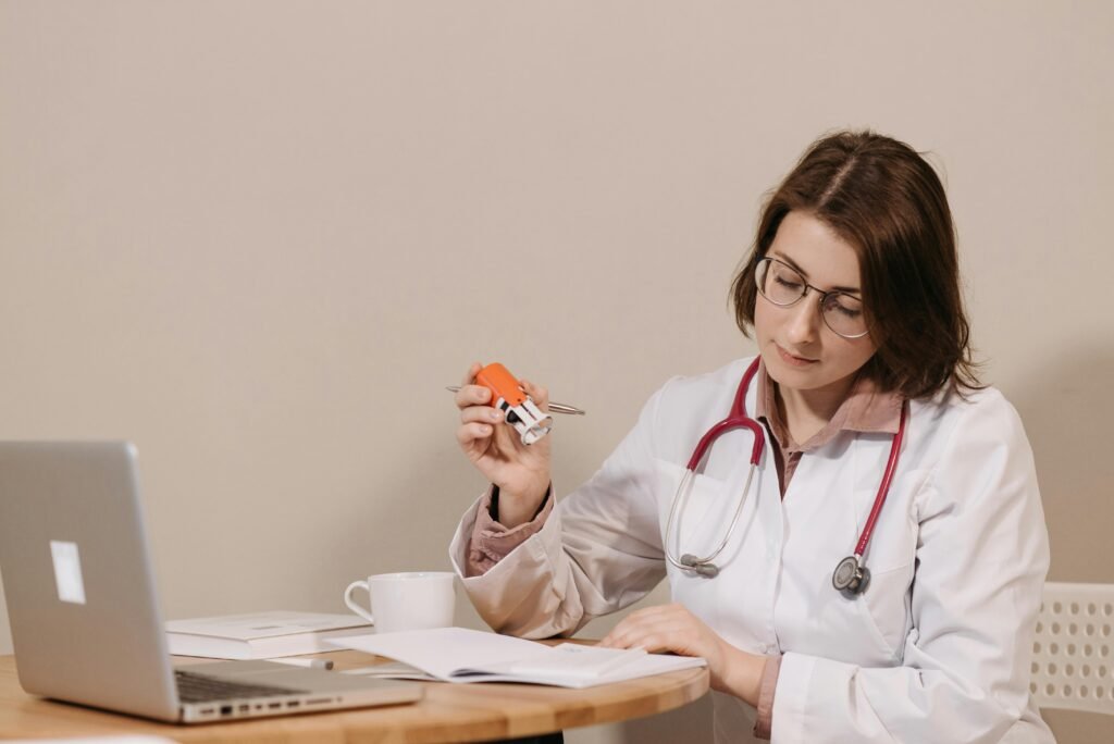 pexels-photo-5998472-5998472 A focused female doctor reviews medical documents while sitting at her desk with a stethoscope.
