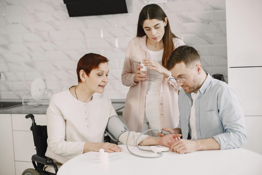 pexels-photo-7446750-7446750 A family member assists a senior in a wheelchair with a blood pressure check, symbolizing care and wellbeing.